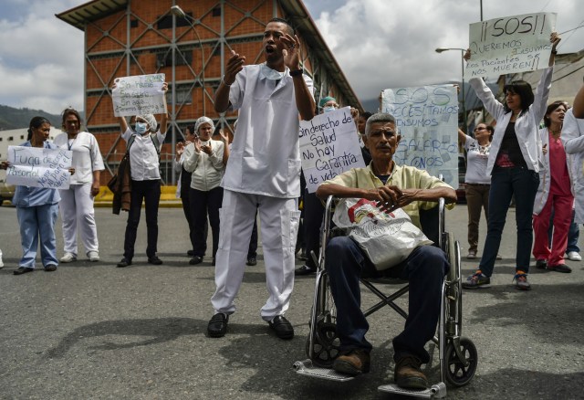 Health workers and patients protest for the lack of medicines, medical supplies and poor conditions in hospitals, in Caracas on April 17, 2018. Doctors and nurses protest against the health crisis in Venezuela, currently in the midst of a deep economic and political crisis and where health authorities have reported a rise in vaccine-preventable diseases. / AFP PHOTO / Luis ROBAYO