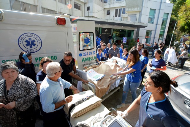 Medical staffers evacuate inmates following a gas leak explosion at a private clinic, in Concepcion, about 550 km south of Santiago,on April 21, 2018. An explosion caused by a gas leak in the Aleman sanatorium, a private clinic in Concepcion, left three dead and about 50 injured, said a preliminary report by the Chilean police. / AFP PHOTO / GUILLERMO SALGADO