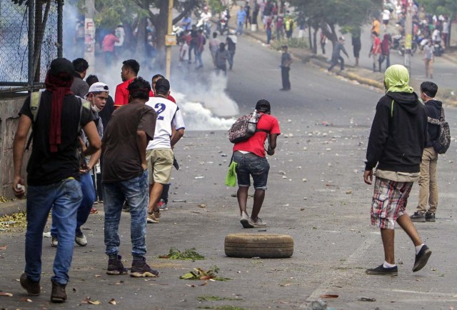 Estudiantes chocan con agentes de la policía antidisturbios cerca del Colegio Técnico de Nicaragua durante una protesta contra las reformas del gobierno en el Instituto de Seguridad Social (INSS) en Managua el 21 de abril de 2018. Un manifestante y un policía murieron en la capital nicaragüense, Managua, luego de que las manifestaciones por la reforma de las pensiones se volvieran violentas el jueves por la noche, dijeron las autoridades. Las muertes se produjeron después de las protestas de opositores y partidarios de una nueva ley, que aumenta las contribuciones de los empleadores y los empleados, mientras que reduce el monto total de las pensiones en un cinco por ciento, sacudió la capital por segundo día consecutivo. / AFP PHOTO / INTI OCON