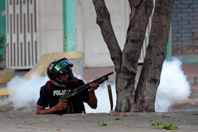 A riot policeman holds his weapon during clashes with university students protesting over a controversial reform to the pension plans of the Nicaraguan Social Security Institute (INSS) in Managua, Nicaragua April 20, 2018. REUTERS/Oswaldo Rivas