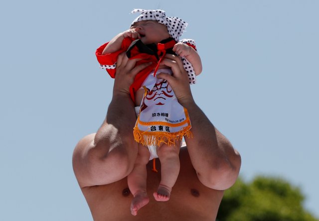 Un bebé llora en los brazos de un peleador de zumo amateur |FOTO: REUTERS/Issei Kato