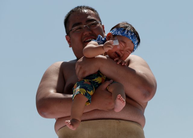 Un bebé llora en los brazos de un peleador de zumo amateur |FOTO: REUTERS/Issei Kato