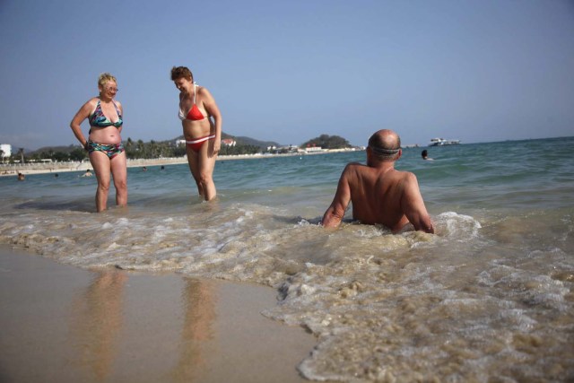 RTC02. SANYA (CHINA), 30/6/2011.- Un hombre se relaja en la orilla en la playa de Dadonghai en la isla de Sanya en la provincia de Hainan en China hoy, jueves, 30 de junio de 2011. Debido a su buen clima y precios relativamente baratos, Sanya se ha convertido en un destino vacacional para los rusos. EFE/Qilai Shen