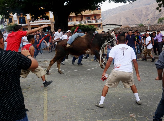 ACOMPAÑA CRÓNICA: GUATEMALA SEMANA SANTA GU6005. SACAPULAS (GUATEMALA), 31/03/2018.- Pobladores participan hoy, sábado 31 de marzo 2018, en la tradicional festividad de "Los Toros" en Sacapulas (Guatemala). "¡Ya llegó la hora de los toros!". Esta frase marca la señal de una tradición única en Guatemala en la que centenares de personas corren delante de un grupo de toros para quemar a su particular "Judas" de trapo y así extirpar las malas energías. EFE/Esteban Biba