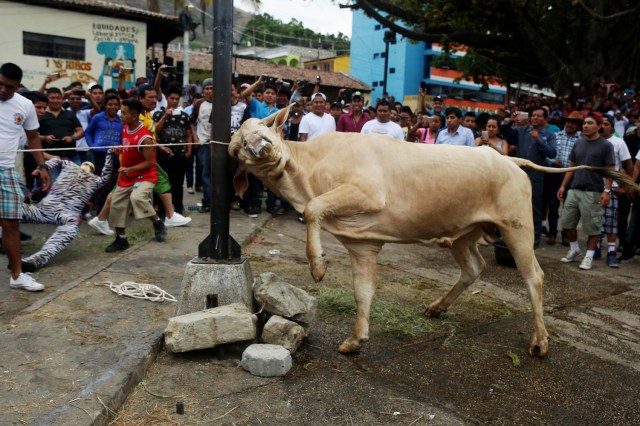 ACOMPAÑA CRÓNICA: GUATEMALA SEMANA SANTA GU6017. SACAPULAS (GUATEMALA), 31/03/2018.- Pobladores asisten hoy, sábado 31 de marzo 2018, a la tradicional festividad de "Los Toros" en Sacapulas (Guatemala). "¡Ya llegó la hora de los toros!". Esta frase marca la señal de una tradición única en Guatemala en la que centenares de personas corren delante de un grupo de toros para quemar a su particular "Judas" de trapo y así extirpar las malas energías. EFE/Esteban Biba