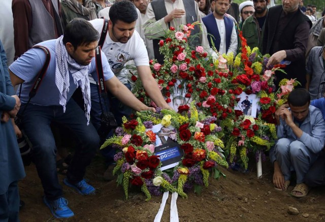 KAB01. KABUL (AFGANISTÁN), 30/04/2018.- Periodistas colocan una corona de flores junto a la tumba de Shah Marai, fotógrafo de la agencia de noticias francesa AFP, que murió en un atentado en Kabul, Afganistán, hoy, 30 de abril de 2018. El grupo yihadista Estado Islámico (EI) perpetró hoy un doble atentado en Kabul que ha acabado con la vida de 25 personas, entre ellas nueve periodistas, y dejado heridas a otras 49, en una de las jornadas más duras desde 2001 para la prensa en Afganistán. EFE/STRINGER