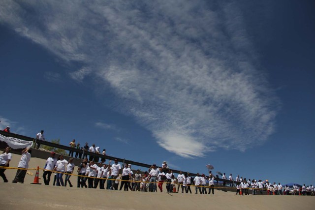 Mexican families living in Mexico arrive to meet with their relatives living in US at the border line in the bank of Rio Grande in the framework of the event called "Abrazos No Muros" (Hugs, not walls) promoted by the Border Network of Human Rights organization in the border line between El Paso, Texas, United States and Ciudad Juarez, Chihuahua state, Mexico on May 12, 2018. / AFP PHOTO / HERIKA MARTINEZ