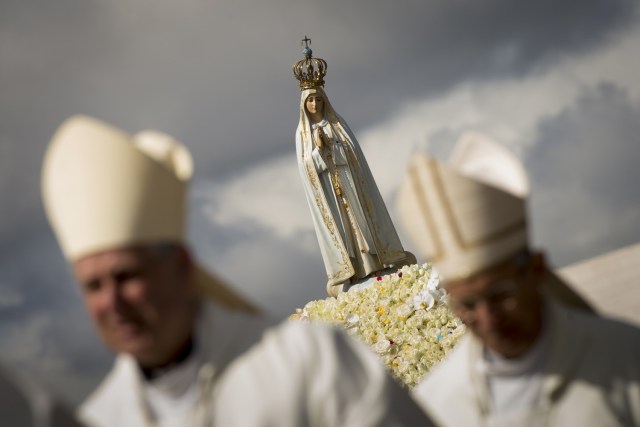 La estatua de Nuestra Señora de Fátima se lleva a cabo durante una ceremonia masiva en el santuario de Fátima en Fátima, en el centro de Portugal, el 13 de mayo de 2018. Miles de peregrinos se reunieron en el Santuario de Fátima para celebrar el aniversario del milagro de Fátima cuando tres niños pastores afirmaron haber visto a la Virgen María en mayo de 1917. / AFP PHOTO / MIGUEL RIOPA