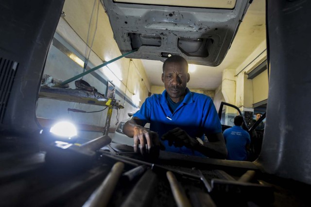 Venezuelan Hugo Alexander works at a locksmith's car shop in Montevideo on May 10, 2018. Exiled Venezuelans have no expectations of the presidential election taking place next May 20 in their home country. / AFP PHOTO / MIGUEL ROJO