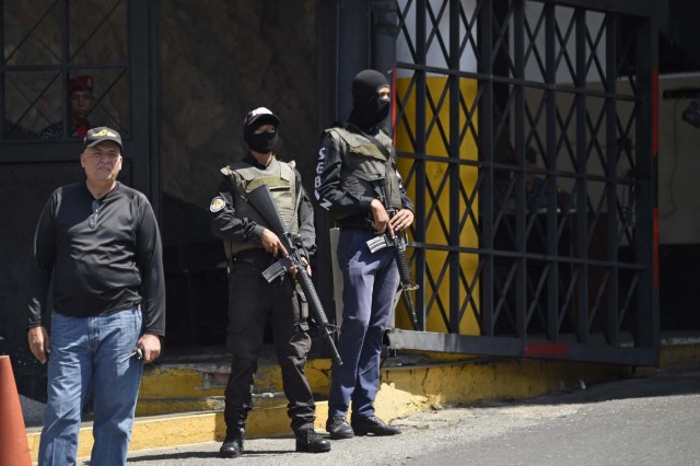 Security forces are seen at the entrance of El Helicoide, the headquarters of the Bolivarian National Intelligence Service (SEBIN), in Caracas, on May 17, 2018, where Venezuelan opponents and a US citizen have seized control of the detention centre. The Venezuelan opponents and a US Mormon missionary, who took control of the cell block area on the eve, are demanding the release of prisoners, according to videos broadcast on social networks. / AFP PHOTO / Juan BARRETO