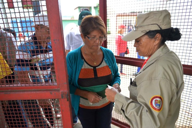 A woman enters a polling station during the presidential elections in Barquisimeto, Venezuela on May 20, 2018 Venezuelans headed to the polls early Sunday to vote in the general elections as incumbent president Nicolas Maduro is seeking a second term in power. / AFP PHOTO / Luis Robayo