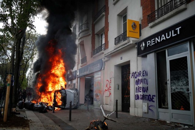 Un automóvil se quema frente a un garaje de automóviles de Renault durante los enfrentamientos en la marcha sindical del Primero de Mayo en París, Francia, el 1 de mayo de 2018. REUTERS / Christian Hartmann