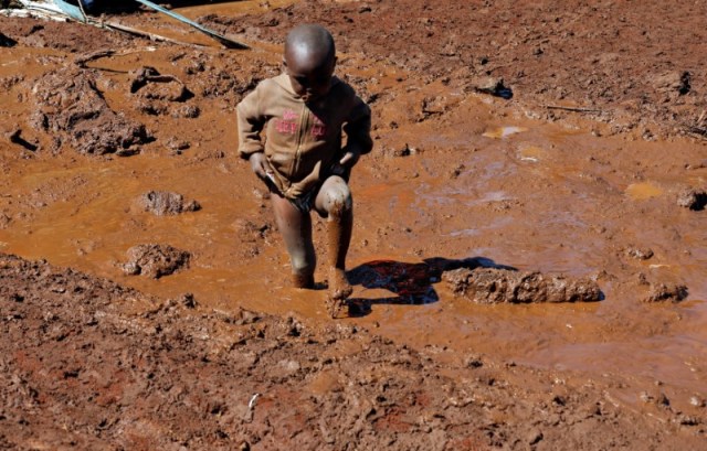 Un niño camina cerca de casas destruidas por una innundacion después de la explosión de una represa, en la ciudad de Solio, cerca de Nakuru, Kenia, el 10 de mayo de 2018. REUTERS / Thomas Mukoya