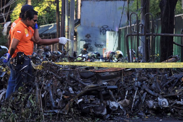 BY11. Surabaya (Indonesia), 13/05 / 2018.- Policías indonesios inspeccionan la escena de la explosión de una bomba frente a una iglesia en Surabaya, Java Oriental, Indonesia, el 13 de mayo de 2018. Según los informes de los medios, al menos once personas han sido murieron y docenas más resultaron heridas después de que ocurrieron explosiones de bombas en tres localidades de Surabaya. EFE / EPA / ROBERT RIZKY 