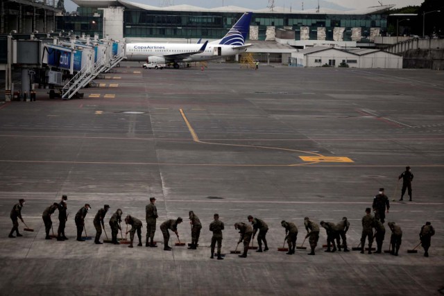 Soldados barren el asfalto cubierto de ceniza en el Aeropuerto Internacional La Aurora luego de que el volcán Fuego estallara violentamente en la ciudad de Guatemala, Guatemala el 3 de junio de 2018. REUTERS / Luis Vargas