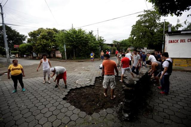 Manifestantes arman una barricada hoy, 11 de junio de 2018, durante enfrentamientos con la Policia Nacional en los barrios de Managua (Nicaragua). Este lunes por la mañana la Policía Nacional y grupos "parapoliciales" atacaron los llamados "barrios orientales" de Managua con armas de guerra, en respuesta a múltiples barricadas que edificó la población en las calles para impedir el paso de fuerzas de choque oficialistas. EFE/Bienvenido Velasco