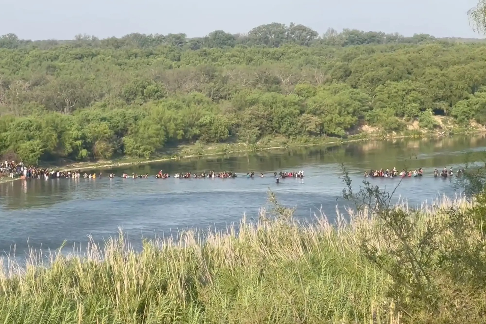 Impresionante VIDEO muestra a un grupo masivo de migrantes cruzando la frontera de Texas