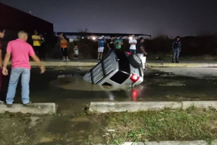 Camioneta cayó dentro de un mega cráter en una calle restringida de Valencia (Fotos)