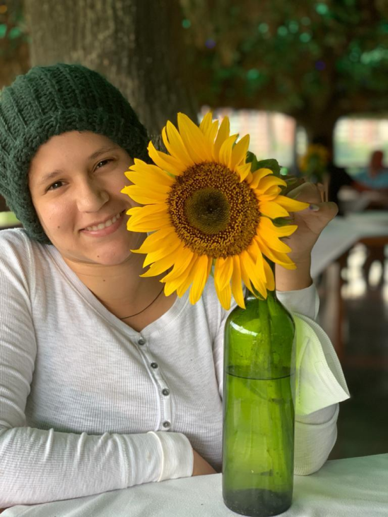 Angie Gomez con un girasol. Foto: Cortesía